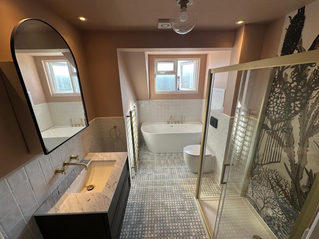 Bathroom renovation in Oxford featuring waterproof decorative wall panels, freestanding bath, bespoke vanity, and patterned floor tiles