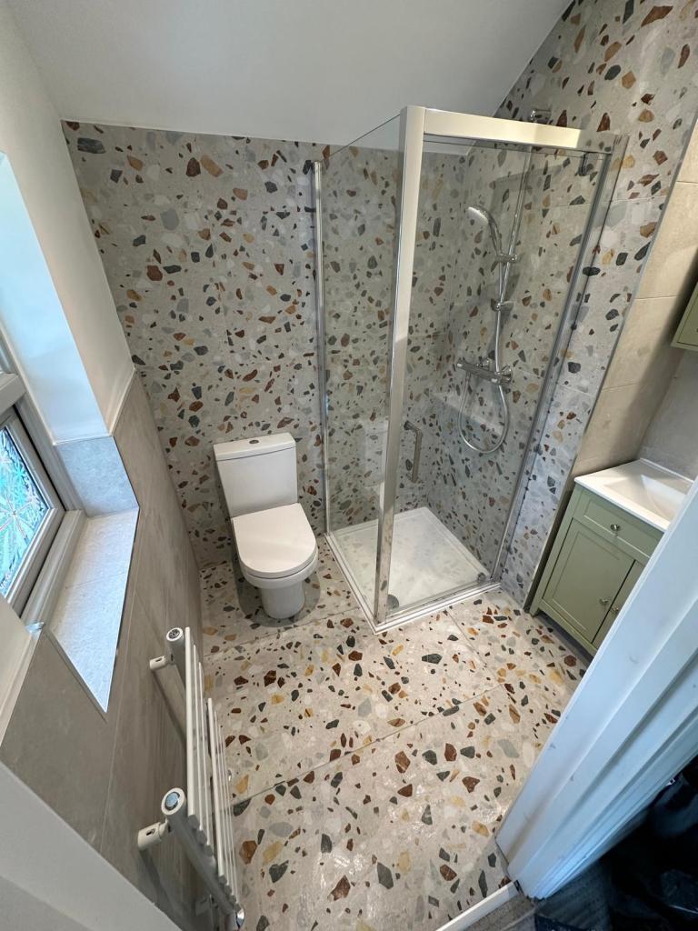 Contemporary shower room installation in Oxford with terrazzo tiling, glass shower enclosure, and modern fixtures