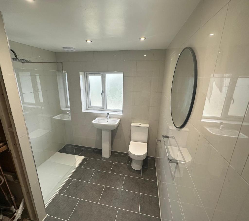 Modern bathroom installation in Oxford with large-format wall tiles, grey porcelain flooring, and walk-in shower